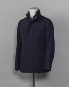 Montecore waterproof field jacket. Four pockets in front and adjustable waistband. Adjustable hood that can be folded inside the collar. So all the classical elements of a proper field jacket plus the added value of a waterproof and breathable technical  material. Four pockets in front Adjustable waist band Adjustable hood inside the collar Waterproof Breathable Taped seams  79% Polyester 21% Polyurethane Art. S04MUCT603 Col. 89 / Navy