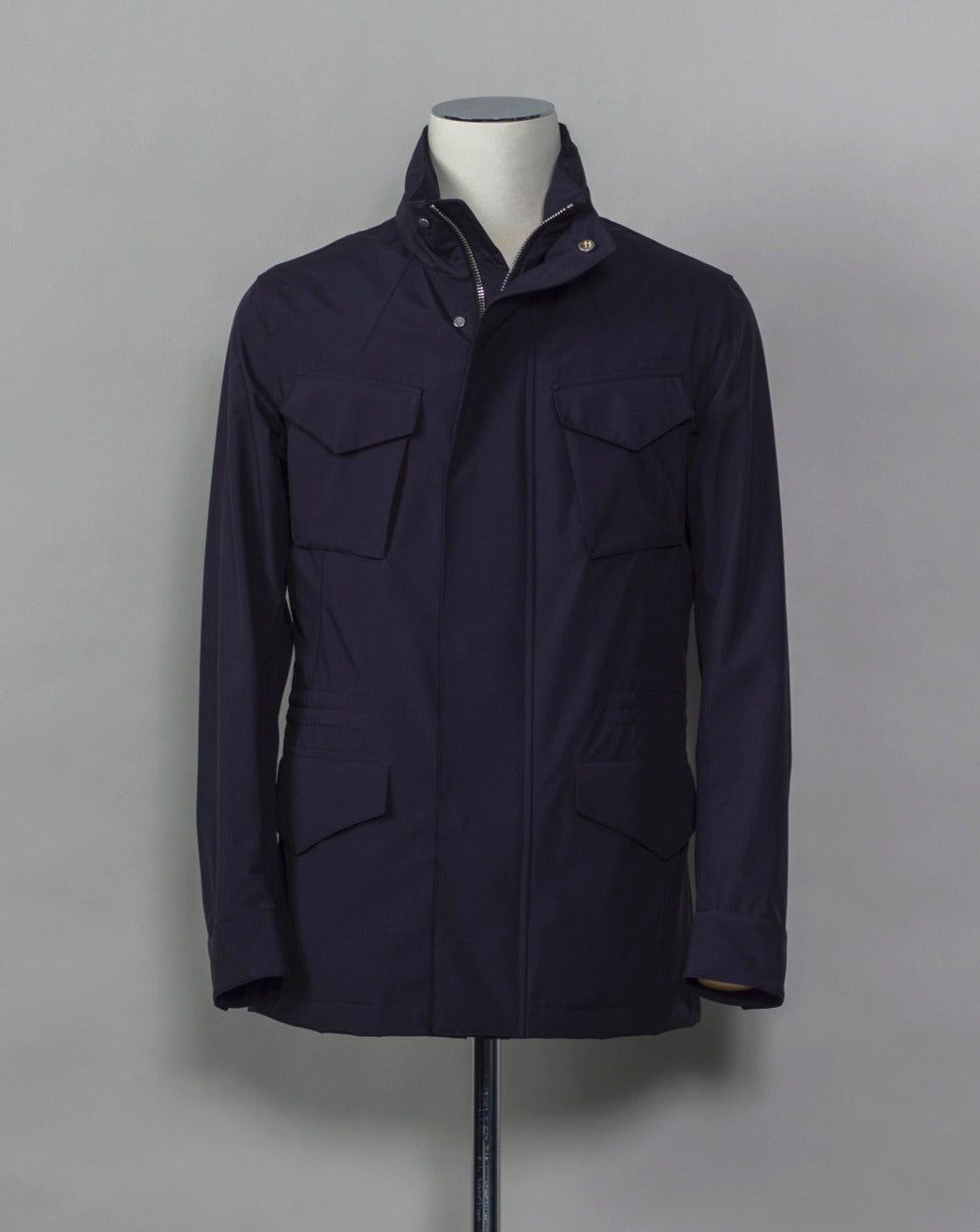 Montecore waterproof field jacket. Four pockets in front and adjustable waistband. Adjustable hood that can be folded inside the collar. So all the classical elements of a proper field jacket plus the added value of a waterproof and breathable technical material. Four pockets in front Adjustable waist band Adjustable hood inside the collar Waterproof Breathable Taped seams 79% Polyester 21% Polyurethane Art. S04MUCT603 Col. 89 / Navy