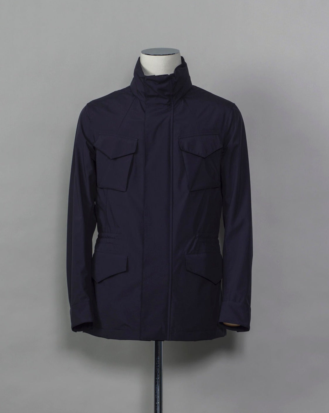 Montecore waterproof field jacket. Four pockets in front and adjustable waistband. Adjustable hood that can be folded inside the collar. So all the classical elements of a proper field jacket plus the added value of a waterproof and breathable technical material. Four pockets in front Adjustable waist band Adjustable hood inside the collar Waterproof Breathable Taped seams 79% Polyester 21% Polyurethane Art. S04MUCT603 Col. 89 / Navy