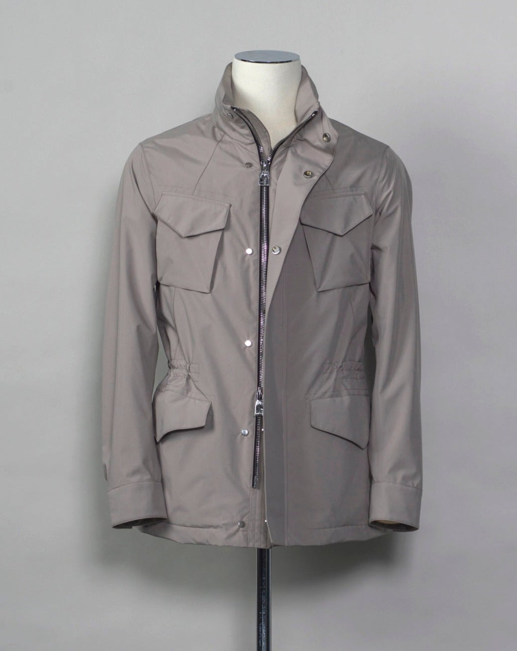 Montecore waterproof field jacket. Four pockets in front and adjustable waistband. Adjustable hood that can be folded inside the collar. So all the classical elements of a proper field jacket plus the added value of a waterproof and breathable technical material. Four pockets in front Adjustable waist band Adjustable hood inside the collar Waterproof Breathable Taped seams 79% Polyester 21% Polyurethane Art. S04MUCT603 Col. 23 / Stone Grey