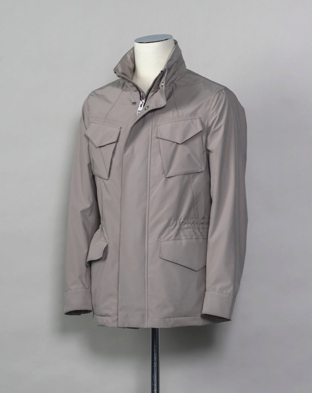 Montecore waterproof field jacket. Four pockets in front and adjustable waistband. Adjustable hood that can be folded inside the collar. So all the classical elements of a proper field jacket plus the added value of a waterproof and breathable technical material. Four pockets in front Adjustable waist band Adjustable hood inside the collar Waterproof Breathable Taped seams 79% Polyester 21% Polyurethane Art. S04MUCT603 Col. 23 / Stone Grey
