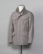 Montecore waterproof field jacket. Four pockets in front and adjustable waistband. Adjustable hood that can be folded inside the collar. So all the classical elements of a proper field jacket plus the added value of a waterproof and breathable technical  material. Four pockets in front Adjustable waist band Adjustable hood inside the collar Waterproof Breathable Taped seams 79% Polyester 21% Polyurethane Art. S04MUCT603 Col. 23 / Stone Grey