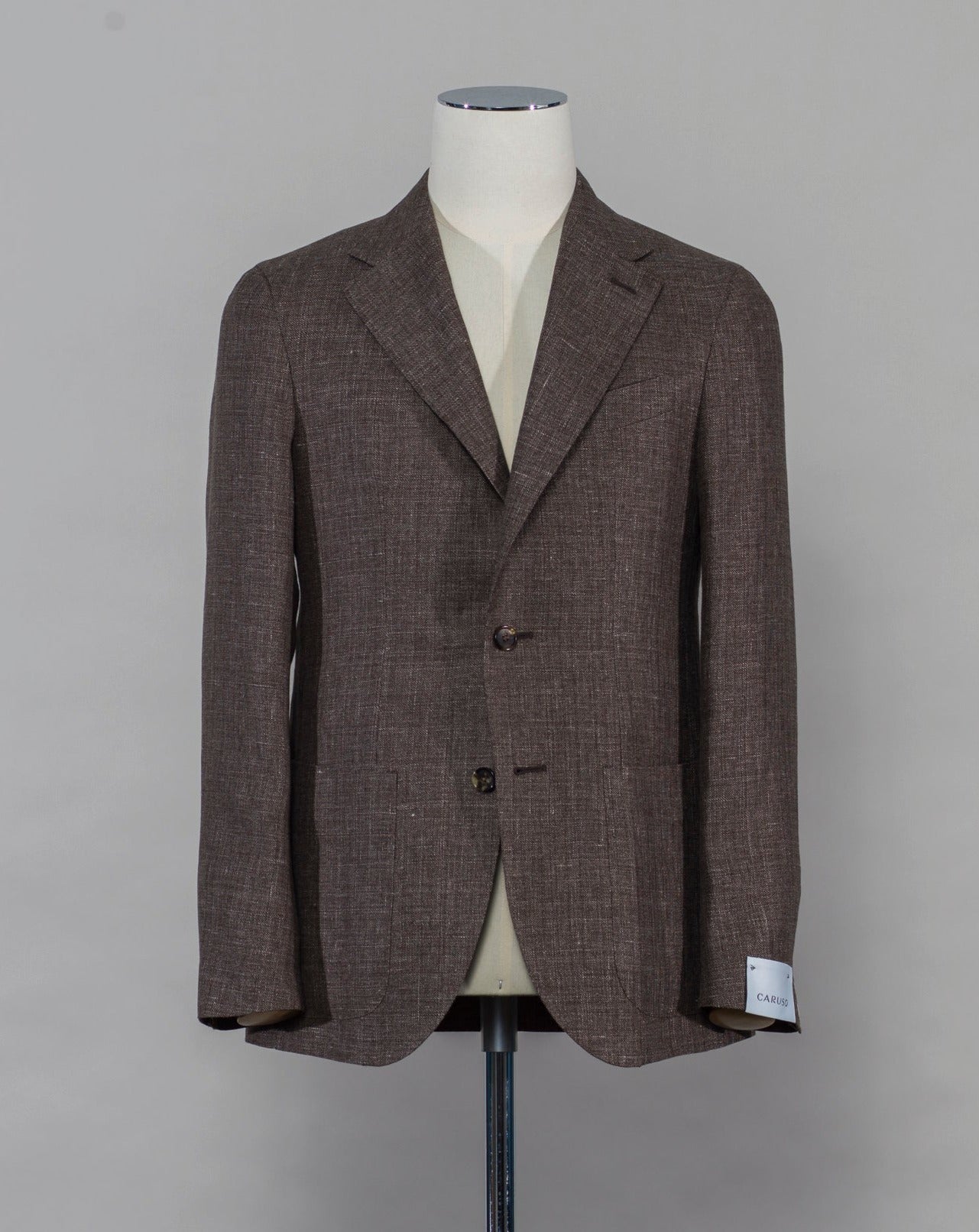 Caruso blazer impeccably tailored in Soragna, Parma, Italy. Stunning lightness and ease of movement without losing the classic tailored elegance. These are some of the ingredients that make Italian tailoring world famous and you can find it all in Caruso garments. Beautiful handmade detailing and naturally with a full canvas structure inside. Full canvas Half lined Unconstructed shoulder Model: Tosca Composition: 58% linen & 42% wool Color: 0560 / Brown Article: BF2CM204A