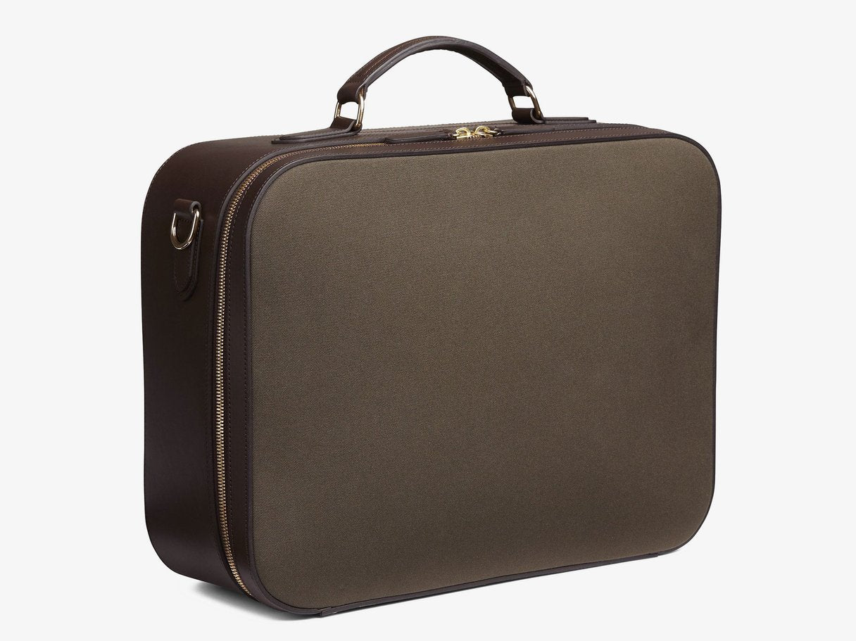 Measurements: L: 46 H: 35 W: 15 cm Material: Tight-woven cotton canvas Composition: CO 94% PU 4% PC 2% / 709 g/m Trimmings: Dark brown, vegetable tanned full-grain bridle leather The M/S Suitcase fuses the contours of heritage travel bags with a minimalist design approach, equipping the carrier with a spacious and aesthetically pleasing bag. A sharp and clean-cut 48-hour suitcase