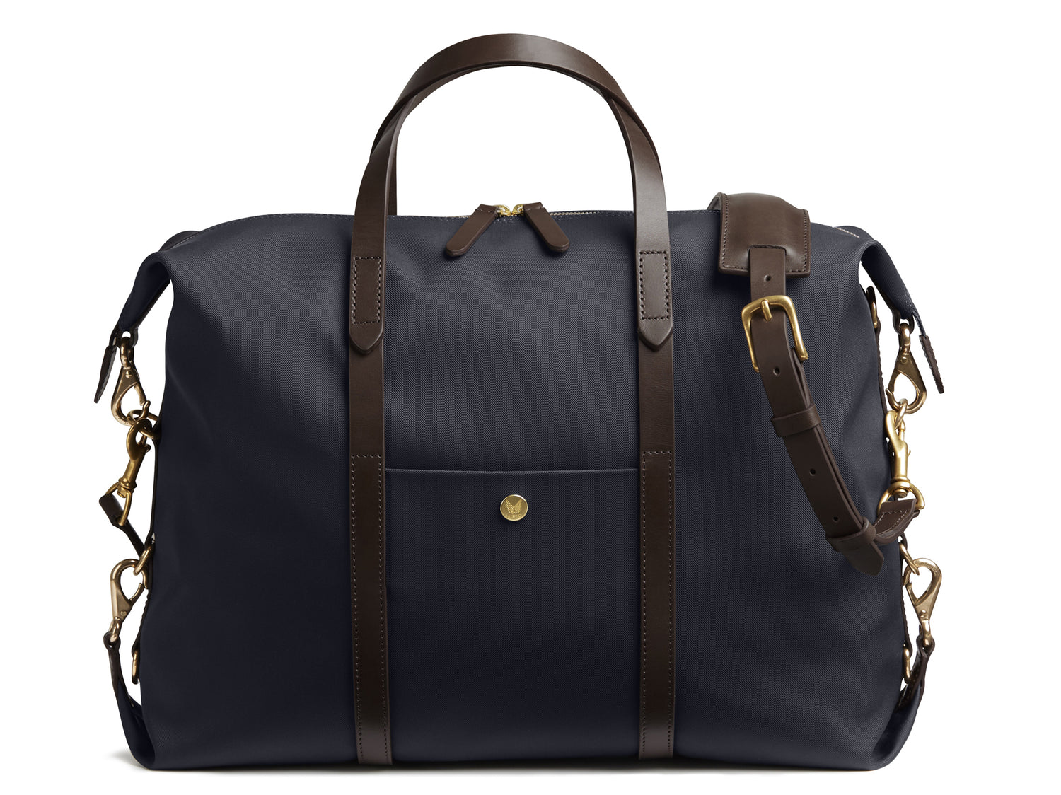 Measurements: L: 42(52) H: 31(41) W: 12(4) cm Body: Waterproof hard woven Italian nylon Fabric composition: PA 42% CO 38% PU 20% / 826g /m Trimmings: Dark brown custom developed vegetable tanned full-grain bridle leather Lining: 100% cotton in army colour Hardware: Solid brass with varnish protection Zipper: Hand polished YKK Excella Art. No. MS121312 A flexible duffle/work bag that can be adjusted in size by attaching the snap hooks in each corner of the bag to the brass D-rings on the gusset