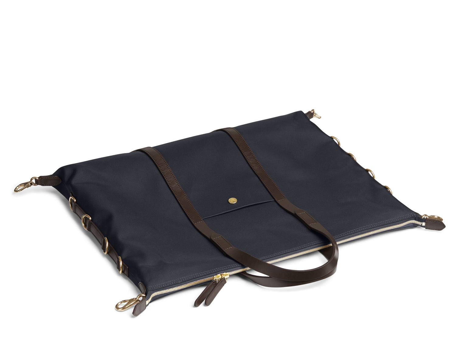 Measurements: L: 42(52) H: 31(41) W: 12(4) cm Body: Waterproof hard woven Italian nylon Fabric composition: PA 42% CO 38% PU 20% / 826g /m Trimmings: Dark brown custom developed vegetable tanned full-grain bridle leather Lining: 100% cotton in army colour Hardware: Solid brass with varnish protection Zipper: Hand polished YKK Excella Art. No. MS121312 A flexible duffle/work bag that can be adjusted in size by attaching the snap hooks in each corner of the bag to the brass D-rings on the gusset