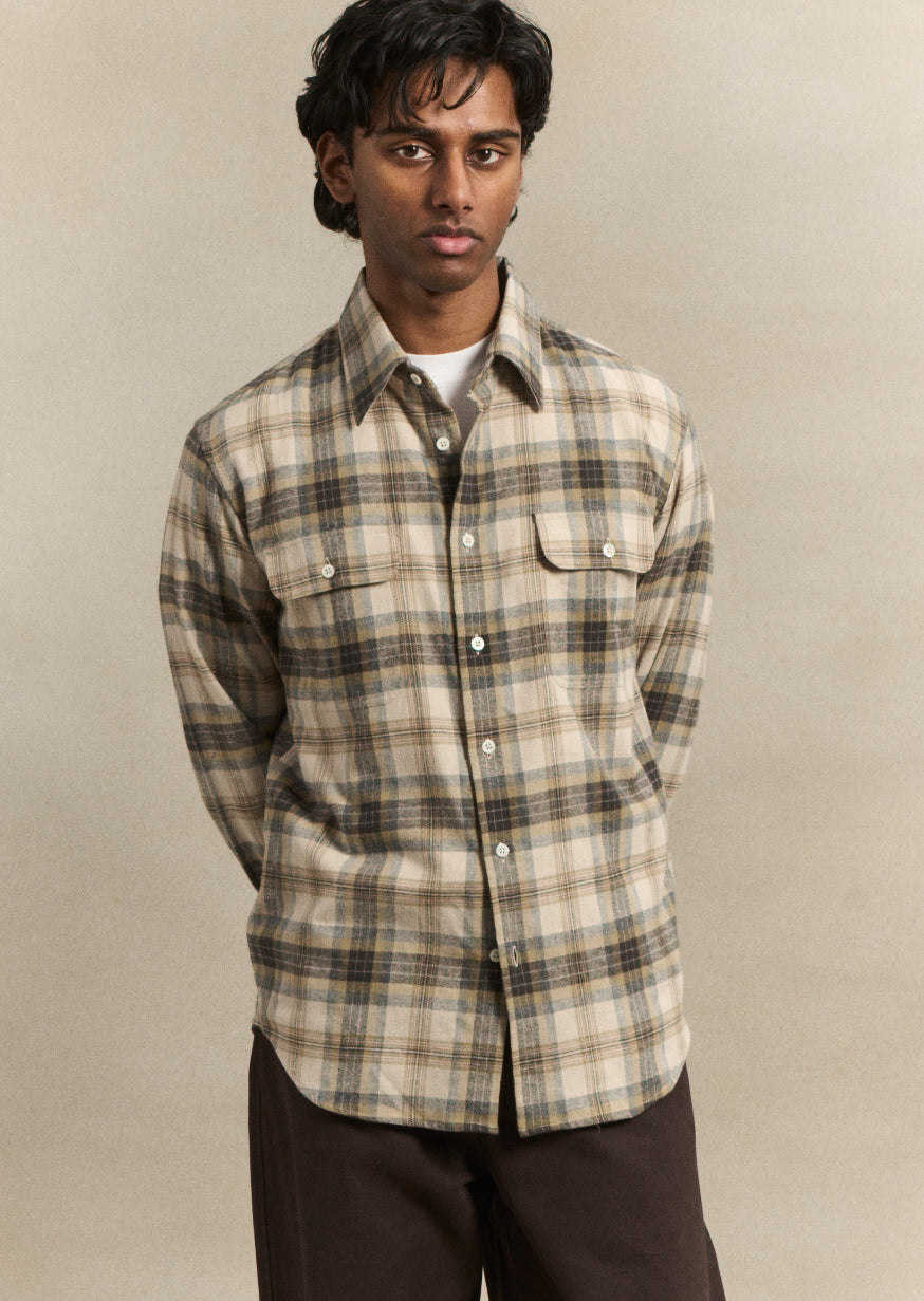 A refined artist's shirt in a subtle grey Camargue check, cut from premium cotton for effortless layering and everyday wear. The relaxed fit and considered proportions reflect De Bonne Facture's commitment to timeless, wearable design, structured enough to pair with tailored trousers or casual knitwear.