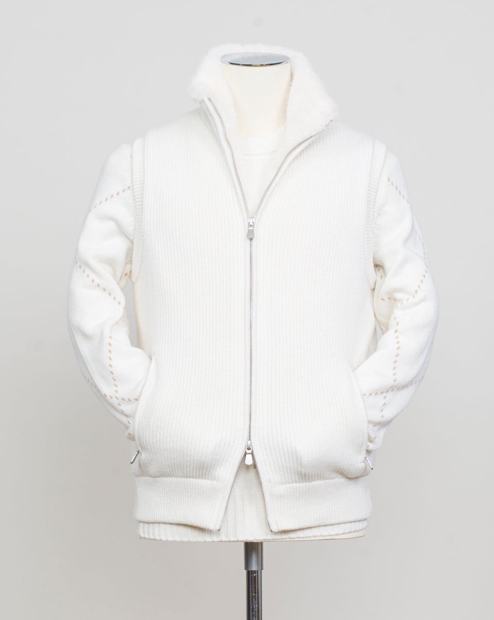 Fisherman's rib 3-ply pure cashmere sleeveless jacket. The metal zippers add a modern, functional touch. The faux fur lining provides warmth and comfort, making it ideal for colder days. The side pockets complete the stylish and practical design.

Outer composition: 100% cashmere
Inner composition: 100% Faux fur
Zipped side pockets
Two-way zipper
Art 23144 15581
Col 001 Cream White
Regular fit
Made in Italy Gran Sasso Eco-Fur & Cashmere Ribbed Vest / White