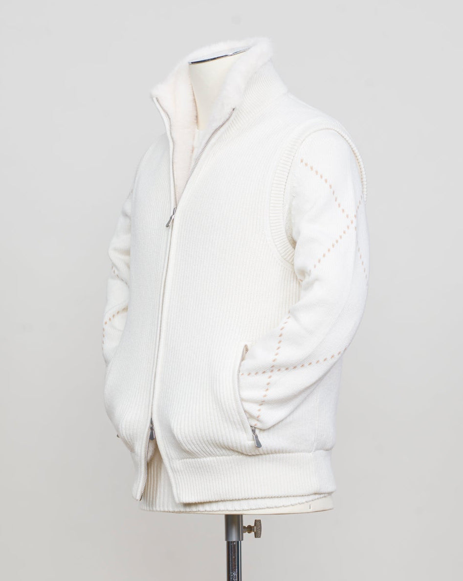 Fisherman's rib 3-ply pure cashmere sleeveless jacket. The metal zippers add a modern, functional touch. The faux fur lining provides warmth and comfort, making it ideal for colder days. The side pockets complete the stylish and practical design.

Outer composition: 100% cashmere
Inner composition: 100% Faux fur
Zipped side pockets
Two-way zipper
Art 23144 15581
Col 001 Cream White
Regular fit
Made in Italy Gran Sasso Eco-Fur & Cashmere Ribbed Vest / White