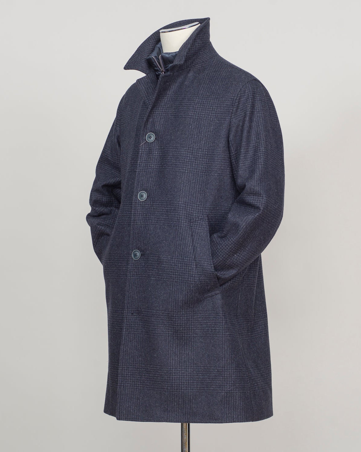 Iconic Herno wool coat in refined glencheck, balancing navy and blue for understated luxury. Fully lined for structured layering across seasons. Features a detachable bib for versatile styling—wear it integrated for classic formality or remove for a streamlined silhouette. Italian craftsmanship and meticulous tailoring define this essential investment piece. Herno Lined Glencheck Wool Coat / Navy & Blue