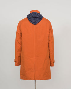 An orange hooded coat shown from the back on a mannequin against a light gray background.