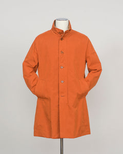 An orange mid-length coat with a stand collar and front buttons, displayed on a mannequin against a light gray background.