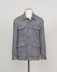 A gray textured jacket displayed on a mannequin torso with a stand against a plain light gray background.