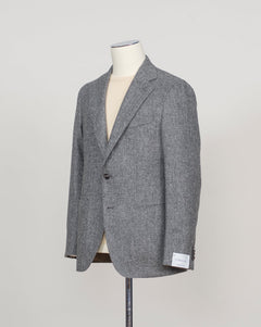A gray textured blazer displayed on a cream-colored mannequin torso, set against a plain light gray background.