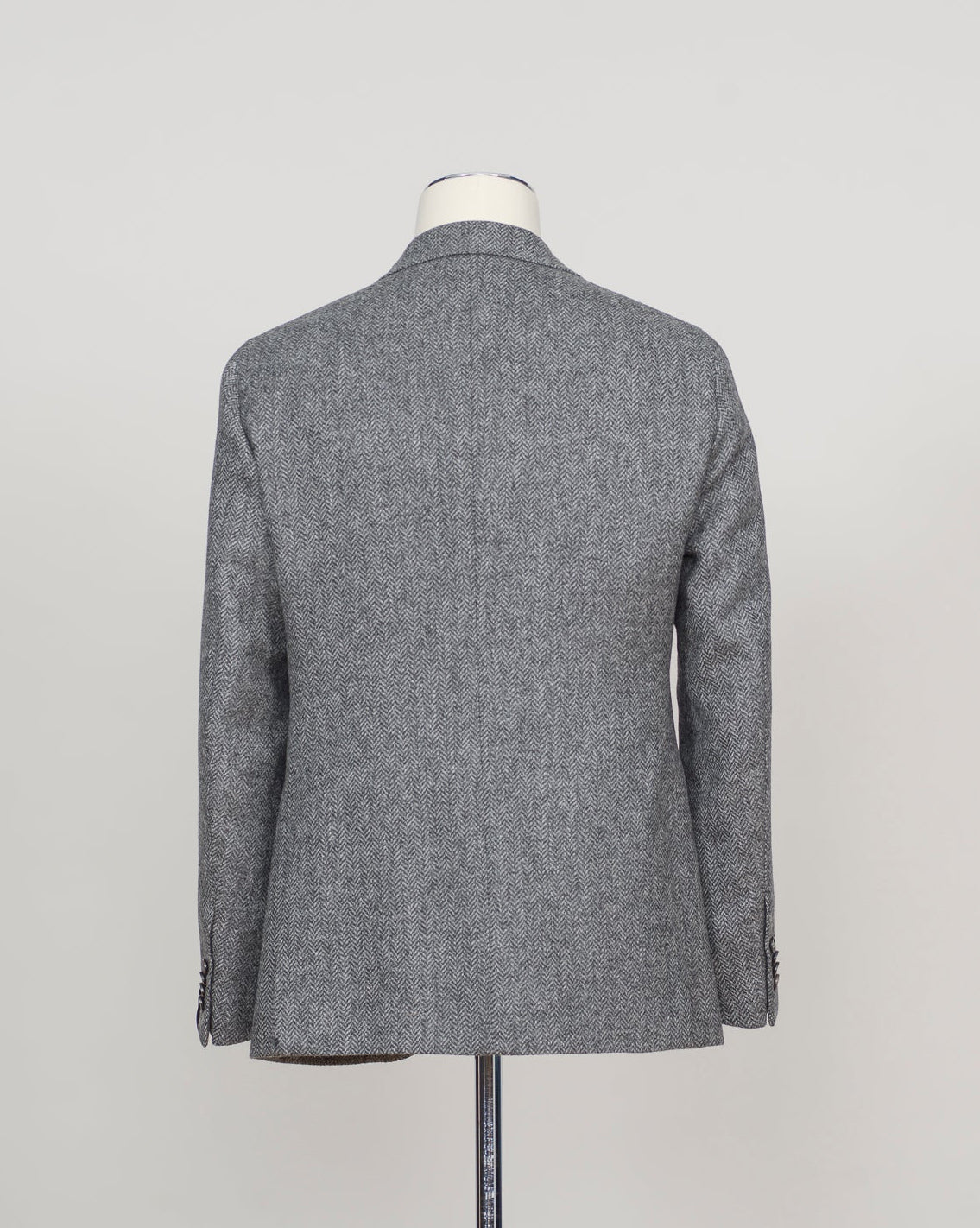 A gray textured wool blazer shown from the back on a dress form mannequin against a light gray studio background.