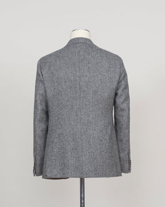 A gray textured wool blazer shown from the back on a dress form mannequin against a light gray studio background.