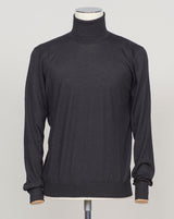 Luxurious roll neck in a refined blend of wool, cashmere and silk. The dark brown hue pairs effortlessly with tailored trousers and formal wear. Gran Sasso's Italian craftsmanship ensures a sumptuous drape and enduring comfort. A timeless layering essential for the discerning wardrobe. &nbsp;Gran Sasso Wool Cashmere &amp; Silk Roll Neck / Black