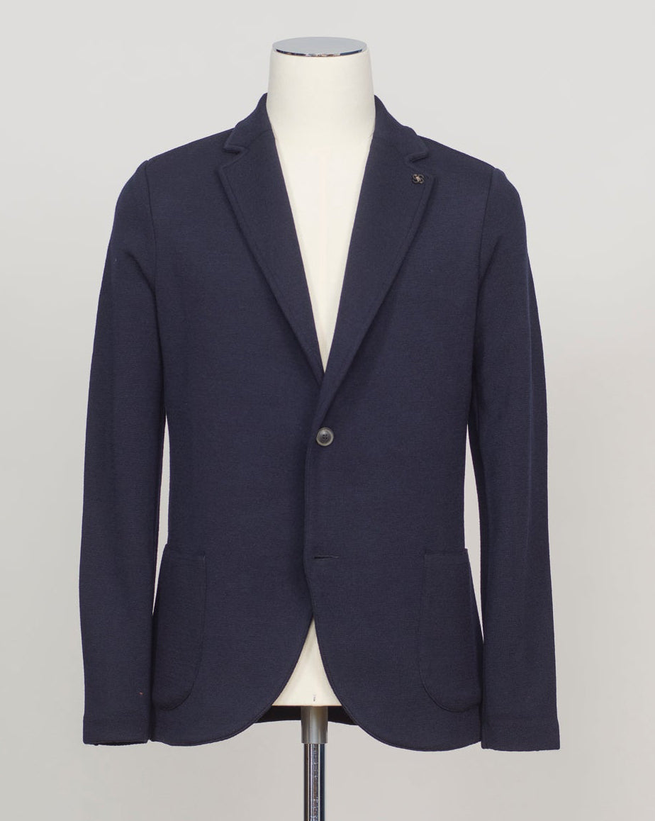 Refined elegance in pure merino. Gran Sasso's knitted blazer in navy delivers structured sophistication without formality—a foundation piece that transitions seamlessly from office to evening. Engineered for layering and designed to last. Gran Sasso Knitted Blazer / Navy 
