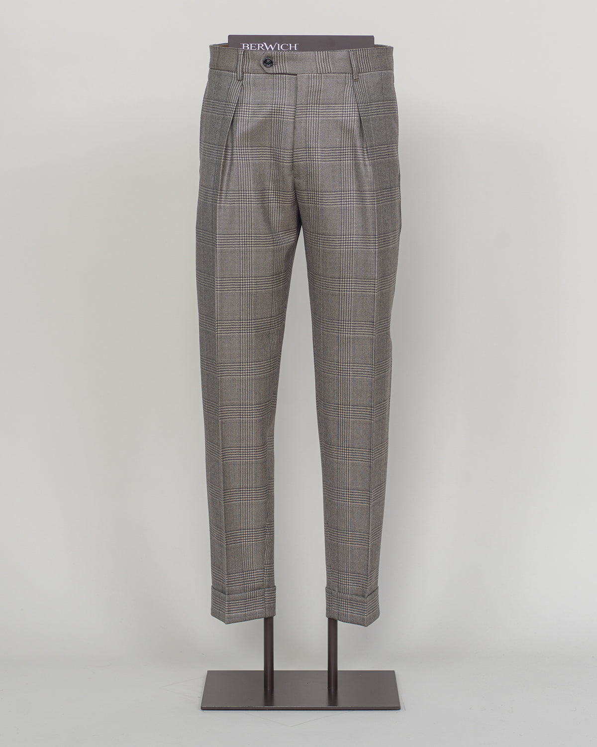 Berwich's Chiaia trousers showcase Italian tailoring heritage with a refined long glencheck pattern in warm greige. Cut with a contemporary silhouette and finished with precision pleating, these trousers balance classic structure with modern sophistication. The carefully selected fabric drapes with quiet elegance, making them an essential foundation for curated menswear wardrobes that demand both substance and understated style.