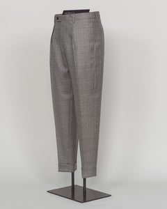 Berwich's Chiaia trousers showcase Italian tailoring heritage with a refined long glencheck pattern in warm greige. Cut with a contemporary silhouette and finished with precision pleating, these trousers balance classic structure with modern sophistication. The carefully selected fabric drapes with quiet elegance, making them an essential foundation for curated menswear wardrobes that demand both substance and understated style.