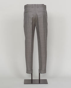 Berwich's Chiaia trousers showcase Italian tailoring heritage with a refined long glencheck pattern in warm greige. Cut with a contemporary silhouette and finished with precision pleating, these trousers balance classic structure with modern sophistication. The carefully selected fabric drapes with quiet elegance, making them an essential foundation for curated menswear wardrobes that demand both substance and understated style.