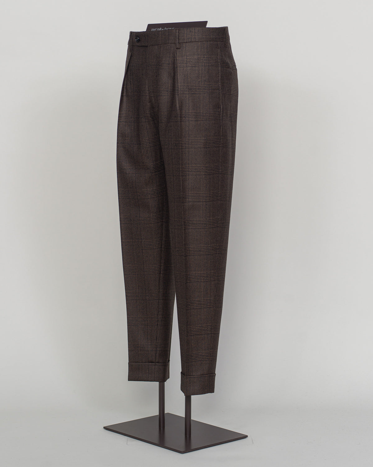 pic2 Berwich's Chiaia trousers showcase Italian tailoring heritage with a refined long glencheck pattern in warm brown. Cut with a contemporary silhouette and finished with precision pleating, these trousers balance classic structure with modern sophistication. The carefully selected fabric drapes with quiet elegance, making them an essential foundation for curated menswear wardrobes that demand both substance and understated style. Berwich Chiaia Long Glencheck Trousers / Brown