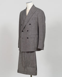 A gray double-breasted suit with a subtle houndstooth pattern, displayed on a mannequin against a light gray background. Tagliatore's double-breasted silhouette merges Italian craftsmanship with refined restraint. The brown and grey palette offers versatility across seasons and occasions—from boardroom formality to sophisticated evening wear. Carefully finished details and structured shoulders create a commanding presence while maintaining contemporary proportion. Cut for the discerning wearer who values ti