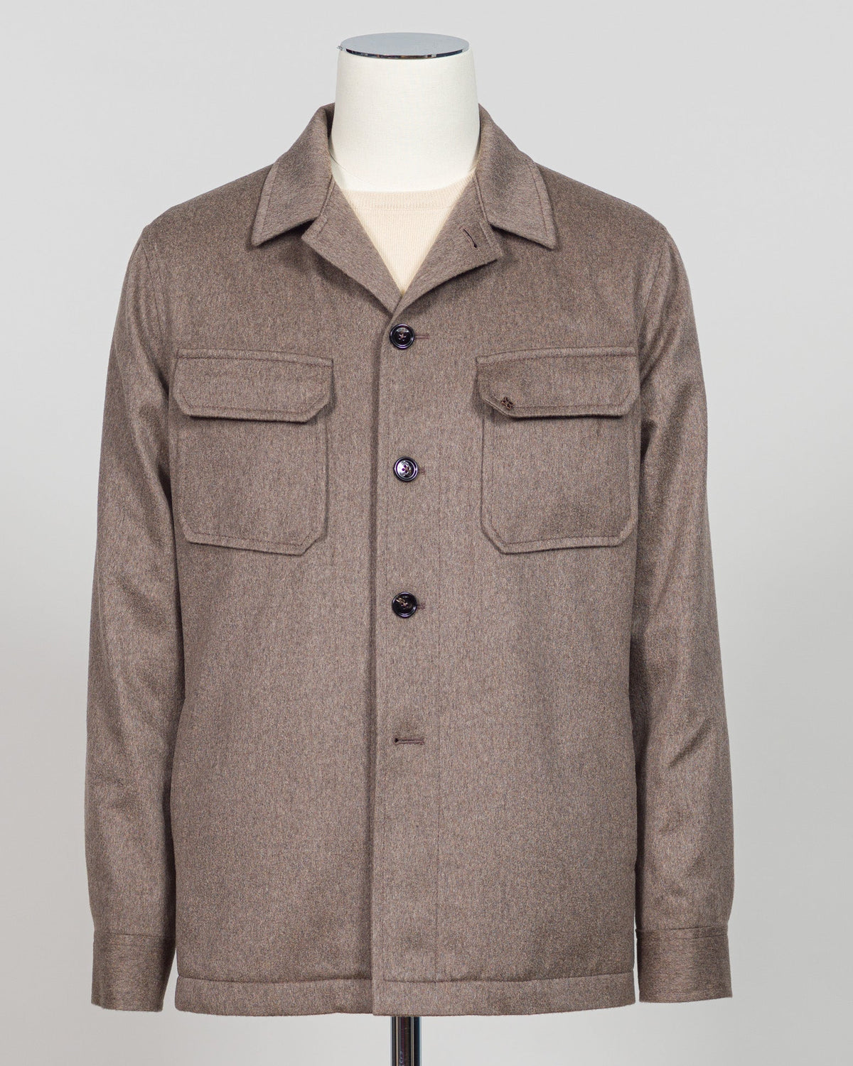 A brown textured jacket displayed on a mannequin torso against a light gray background. Luxurious overshirt crafted from a cashmere and wool blend in a sophisticated taupe tone. The Tagliatore piece delivers refined layering with a substantial drape and premium hand-feel. Perfect for elevated casual wear or as a versatile shirt jacket that transitions effortlessly through seasons. Italian tailoring meets everyday comfort in this investment piece. Tagliatore Cashmere & Wool Overshirt / Taupe