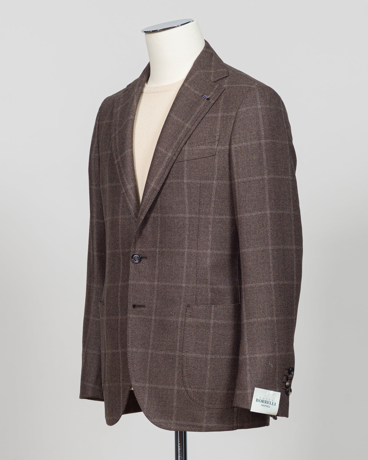 Crafted in Naples by Luigi Borrelli, this windowpane sport jacket exemplifies Italian tailoring precision. The structured brown pattern delivers versatile sophistication—pair it with charcoal trousers for boardroom presence or lighter separates for weekend elegance. Classic cut accommodates layering while maintaining a refined silhouette. A cornerstone piece for discerning menswear collections.