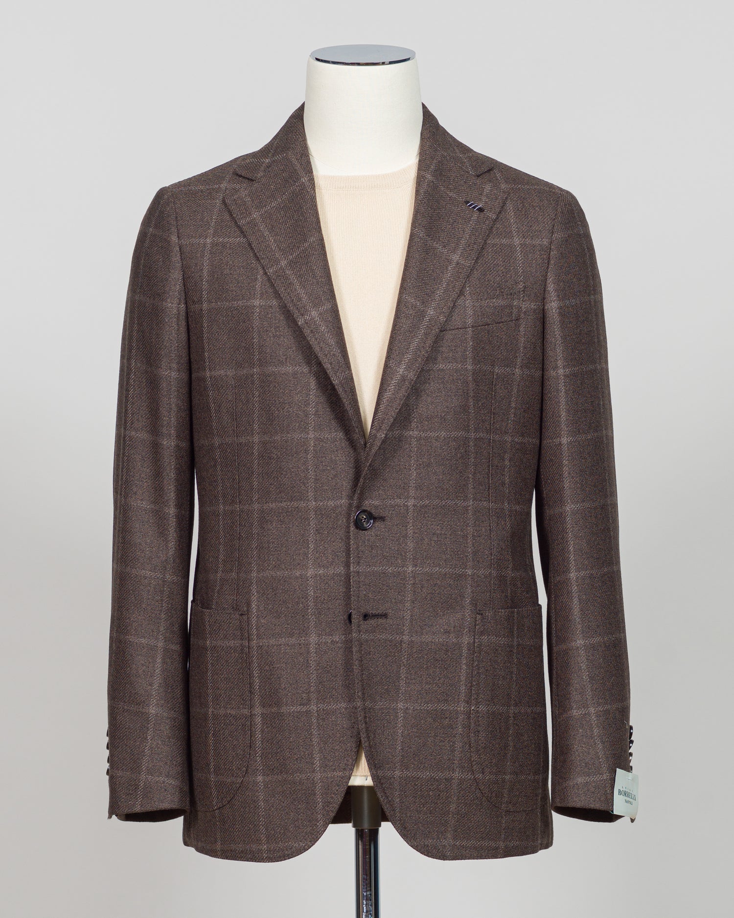 Crafted in Naples by Luigi Borrelli, this windowpane sport jacket exemplifies Italian tailoring precision. The structured brown pattern delivers versatile sophistication—pair it with charcoal trousers for boardroom presence or lighter separates for weekend elegance. Classic cut accommodates layering while maintaining a refined silhouette. A cornerstone piece for discerning menswear collections.