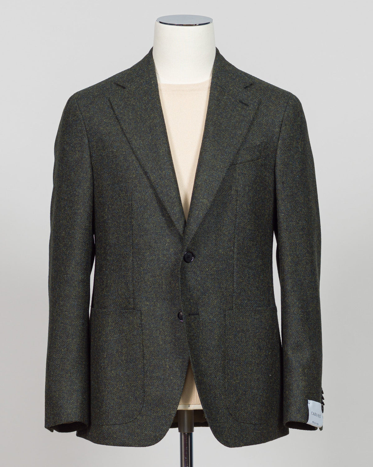 A dark gray textured tweed blazer displayed on a cream-colored mannequin torso against a light gray background. A timeless sport jacket tailored for refined occasions. This Caruso tweed delivers sophisticated texture in a rich dark green, anchoring tailored looks with understated elegance. The natural fiber construction promises durability and breathability, while the classic cut pairs seamlessly with dress trousers or smart casual wear.

Caruso's meticulous craftsmanship ensures a jacket built to last—one 