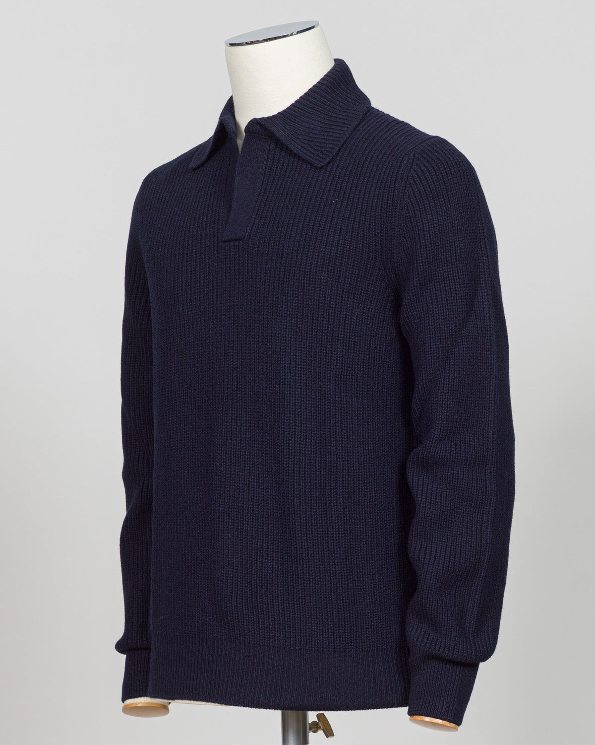 A dark navy blue ribbed knit polo sweater displayed on a white mannequin torso against a light gray background.  Timeless ribbed polo in navy from Gran Sasso, Italian craftsmanship meets understated elegance. Refined knit construction sits comfortably between casual and formal wear. An essential layer for the discerning wardrobe. Gran Sasso Ribbed Polo / Navy