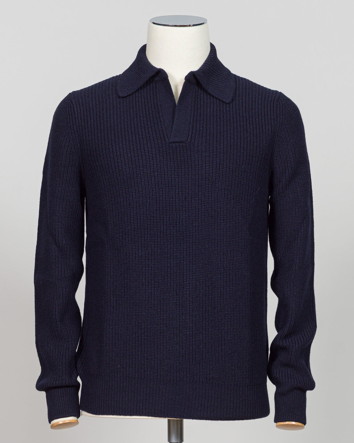 A dark navy blue ribbed knit polo sweater displayed on a white mannequin torso against a light gray background.  Timeless ribbed polo in navy from Gran Sasso, Italian craftsmanship meets understated elegance. Refined knit construction sits comfortably between casual and formal wear. An essential layer for the discerning wardrobe. Gran Sasso Ribbed Polo / Navy