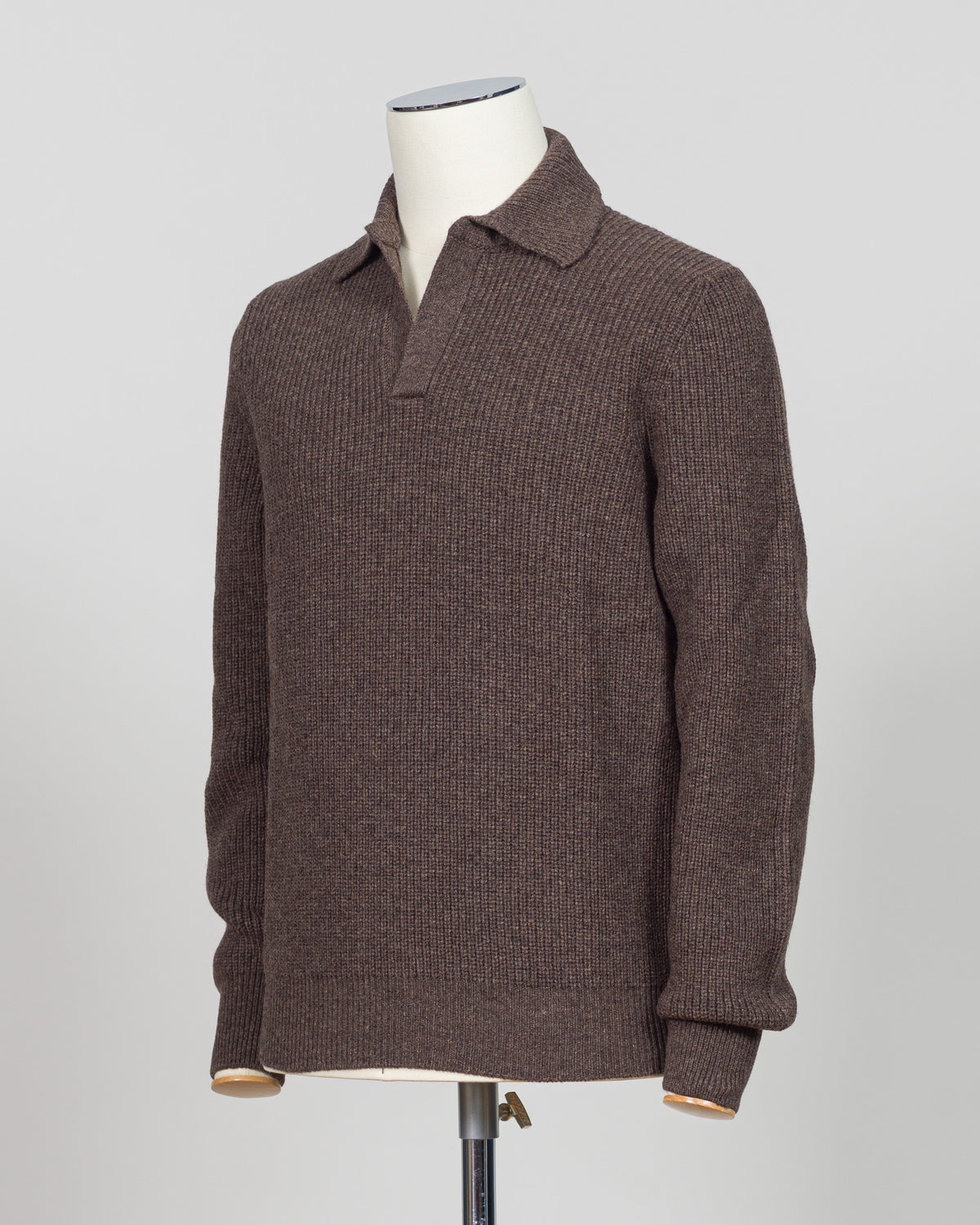 A ribbed knit polo sweater in a dark brown color, displayed on a white mannequin torso against a light gray background.  A refined ribbed polo in deep brown. Gran Sasso's signature knit construction offers subtle texture and timeless appeal. Perfect layered or worn alone for effortless sophistication. Gran Sasso Ribbed Polo / Brown