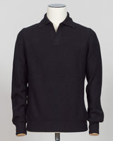 A black ribbed knit polo sweater displayed on a white mannequin torso against a light gray studio background.  A refined essentials piece crafted from premium ribbed knit. The Gran Sasso polo delivers timeless elegance through its structured fabric and clean lines — perfect for layering or worn alone. Black colourway suits any wardrobe foundation. Gran Sasso Ribbed Polo / Black