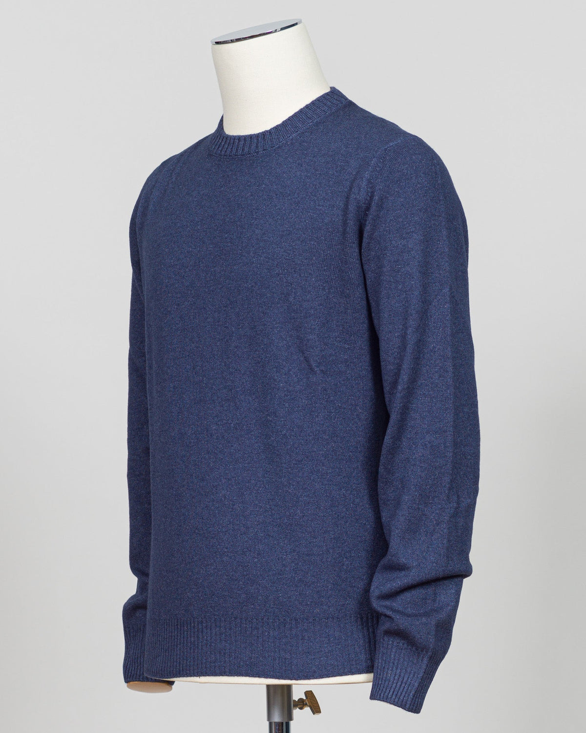 A navy blue knit crewneck sweater displayed on a white mannequin torso against a light gray studio background. Italian craftsmanship meets timeless elegance in this Gran Sasso vintage crewneck. Constructed from premium yarns with meticulous attention to detail, this navy essential delivers versatile sophistication for refined wardrobes. The classic crew silhouette and refined knit construction ensure enduring style and comfort across seasons. A foundation piece worthy of investment.