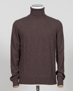 A dark brown knit turtleneck sweater displayed on a mannequin torso against a light gray background. Italian craftsmanship meets understated elegance. This Gran Sasso cashmere roll neck in oat delivers refined warmth through premium fibers and meticulous construction. A versatile layering piece that anchors both formal and relaxed wardrobes with timeless appeal. Gran Sasso Cashmere Roll Neck / Dark Brown