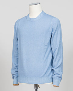 A light blue crewneck sweater displayed on a white mannequin torso against a light gray studio background. Italian luxury knitwear in a soft light blue. Gran Sasso's refined crewneck delivers timeless sophistication with superior craftsmanship—a versatile layering piece that pairs effortlessly with tailored trousers or casual separates. Premium construction ensures lasting comfort and durability. Gran Sasso Vintage Crewneck / Light Blue