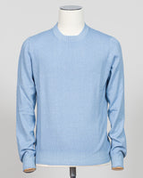 A light blue crewneck knit sweater displayed on a white mannequin torso against a neutral light gray  background. Italian luxury knitwear in a soft light blue. Gran Sasso's refined crewneck delivers timeless sophistication with superior craftsmanship—a versatile layering piece that pairs effortlessly with tailored trousers or casual separates. Premium construction ensures lasting comfort and durability. Gran Sasso Vintage Crewneck / Light Blue