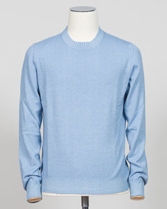 A light blue crewneck knit sweater displayed on a white mannequin torso against a neutral light gray  background. Italian luxury knitwear in a soft light blue. Gran Sasso's refined crewneck delivers timeless sophistication with superior craftsmanship—a versatile layering piece that pairs effortlessly with tailored trousers or casual separates. Premium construction ensures lasting comfort and durability. Gran Sasso Vintage Crewneck / Light Blue