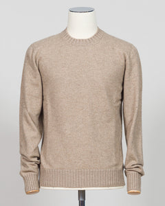 A light beige crewneck knit sweater displayed on a white mannequin torso against a light gray studio background. Italian craftsmanship meets luxurious comfort in this Gran Sasso felted cashmere crewneck. The substantial weight and refined texture of premium cashmere deliver warmth without bulk, while the timeless silver tone pairs effortlessly with tailored trousers or structured outerwear. A foundational piece for the wardrobe—versatile enough for layering, refined enough to stand alone. Gran Sasso
