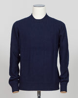 A dark navy blue knit sweater displayed on a white mannequin torso against a light gray studio background. Italian craftsmanship meets luxurious comfort in this Gran Sasso felted cashmere crewneck. The substantial weight and refined texture of premium cashmere deliver warmth without bulk, while the timeless silver tone pairs effortlessly with tailored trousers or structured outerwear.  A foundational piece for the wardrobe—versatile enough for layering, refined enough to stand alone. Gran Sasso Felted Cashm