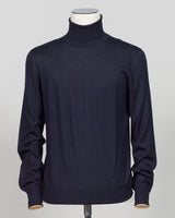 Refined luxury knitwear from Gran Sasso, combining wool, cashmere, and silk in a timeless roll neck silhouette. The navy colorway offers versatile sophistication—equally at home layered under tailoring or worn as a standalone piece. Soft, breathable construction ensures comfort across seasons, while the blend of natural fibers delivers lasting durability and subtle sheen. A wardrobe essential for those who value quality and restraint. Gran Sasso Wool Cashmere &amp; Silk Roll Neck / Navy