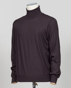 Luxurious roll neck in a refined blend of wool, cashmere and silk. The dark brown hue pairs effortlessly with tailored trousers and formal wear. Gran Sasso's Italian craftsmanship ensures a sumptuous drape and enduring comfort. A timeless layering essential for the discerning wardrobe. Gran Sasso Wool Cashmere &amp; Silk Roll Neck / Dark Brown