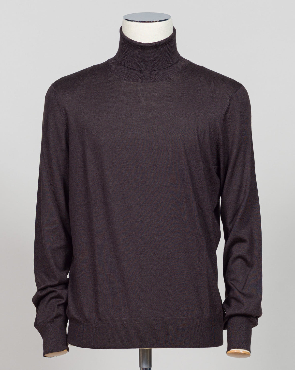 Luxurious roll neck in a refined blend of wool, cashmere and silk. The dark brown hue pairs effortlessly with tailored trousers and formal wear. Gran Sasso's Italian craftsmanship ensures a sumptuous drape and enduring comfort. A timeless layering essential for the discerning wardrobe. Gran Sasso Wool Cashmere & Silk Roll Neck / Dark Brown