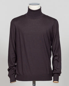 Luxurious roll neck in a refined blend of wool, cashmere and silk. The dark brown hue pairs effortlessly with tailored trousers and formal wear. Gran Sasso's Italian craftsmanship ensures a sumptuous drape and enduring comfort. A timeless layering essential for the discerning wardrobe. Gran Sasso Wool Cashmere &amp; Silk Roll Neck / Dark Brown