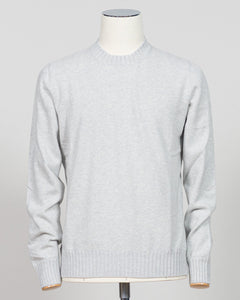 A light gray heathered knit crewneck sweater displayed on a white mannequin torso against a neutral light gray background. Italian craftsmanship meets luxurious comfort in this Gran Sasso felted cashmere crewneck. The substantial weight and refined texture of premium cashmere deliver warmth without bulk, while the timeless silver tone pairs effortlessly with tailored trousers or structured outerwear. A foundational piece for the discerning wardrobe—versatile enough for layering, refined enough to stand alon