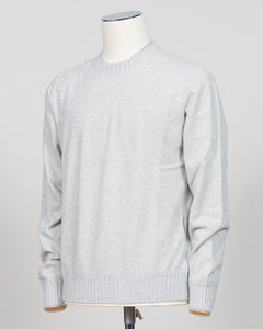 A light gray heather crewneck sweater displayed on a white dress form mannequin against a neutral light gray background. Italian craftsmanship meets luxurious comfort in this Gran Sasso felted cashmere crewneck. The substantial weight and refined texture of premium cashmere deliver warmth without bulk, while the timeless silver tone pairs effortlessly with tailored trousers or structured outerwear. A foundational piece for the discerning wardrobe—versatile enough for layering, refined enough to stand alone.