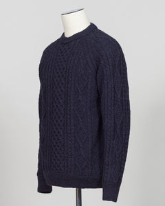 Crafted in collaboration with Casa Isaac, this Aran jumper showcases the timeless appeal of traditional cable knit construction. The deep blue colorway offers versatile styling for both layered and standalone wear. Premium wool blend delivers warmth and durability, while the structured fit maintains its shape through regular wear. A refined staple for the discerning wardrobe.