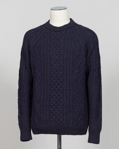 Crafted in collaboration with Casa Isaac, this Aran jumper showcases the timeless appeal of traditional cable knit construction. The deep blue colorway offers versatile styling for both layered and standalone wear. Premium wool blend delivers warmth and durability, while the structured fit maintains its shape through regular wear. A refined staple for the discerning wardrobe.
